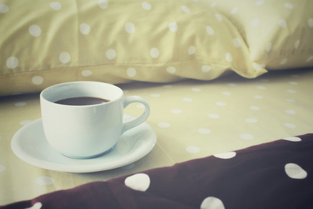 在床上的咖啡杯