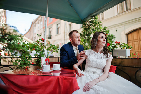 刚刚结婚坐在咖啡馆的红色餐桌上