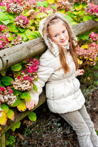 穿着温暖米色外套的可爱小女孩的秋日肖像