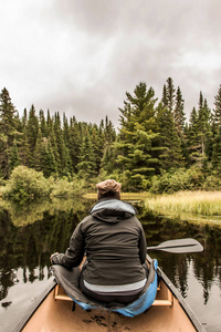 在阿冈昆国家公园的两条河上泛舟的女孩在阴天的加拿大安大略省