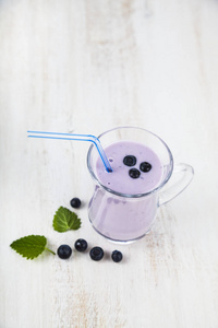 思慕雪或木制的桌子上的蓝莓酸奶。美味