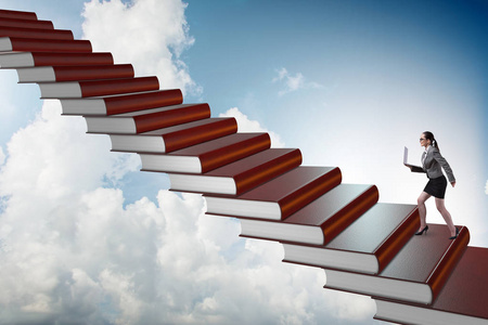 女实业家学生攀登教育书籍的阶梯照片