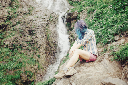 女孩在瀑布附近休息