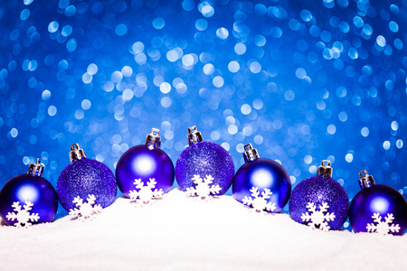 蓝色的圣诞球在雪地上闪烁背景