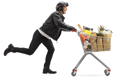 骑自行车的人推着购物车装满食品杂货照片