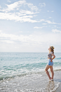 漂亮的模特在海边沙滩上放松，穿上牛仔裤 sho