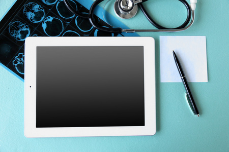 医疗与蓝色的桌子上的空屏平板图片