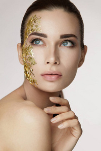 女性皮肤护理。女性与黄金面具的脸上