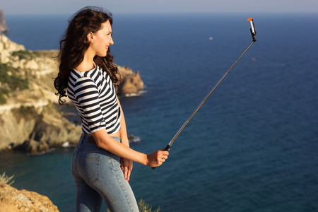 克里米亚的照片旅游女孩在山顶上用棍子自拍照片照片