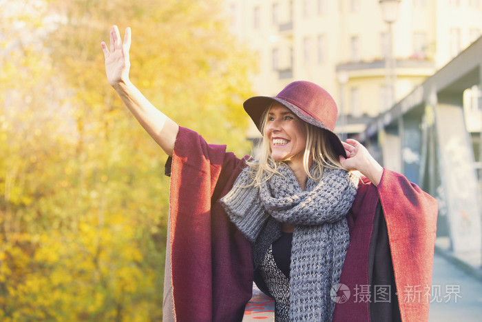 女人站在桥上向某人挥手告别
