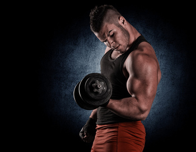 英俊的权力健壮的男人用哑铃自信地寻找照片