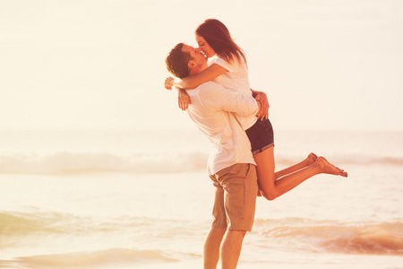 浪漫的情侣在沙滩上亲吻日落时分