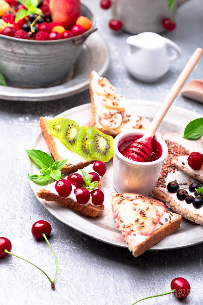 吃干净.节食的概念.谷物面包切片与奶油干酪和各种水果, 浆果, 种子.