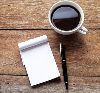 打开空白的白色笔记本 笔和木桌上的咖啡杯子