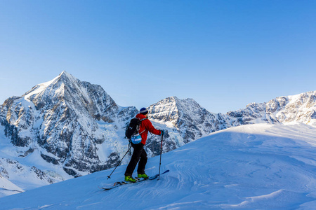 走上沿与白雪皑皑的山脊的登山野外滑雪