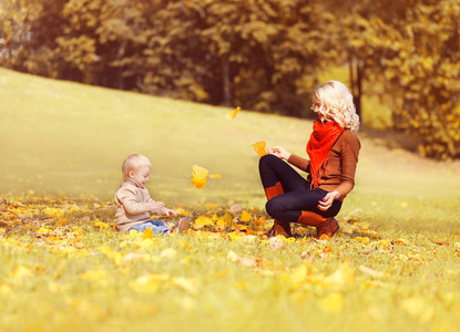 幸福的家庭，在阳光明媚的秋日，母亲和她的孩子一起玩