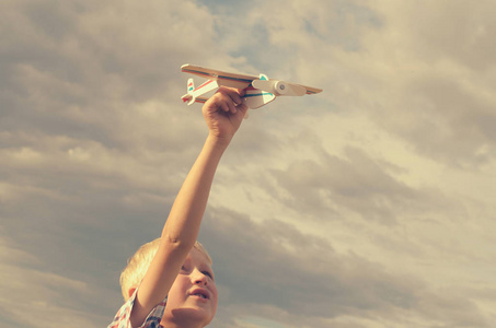 那个男孩用他的手跑进天空的飞机模型