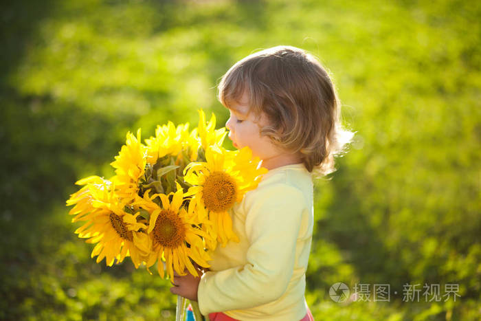 快乐的孩子,与美丽的向日葵花束照片