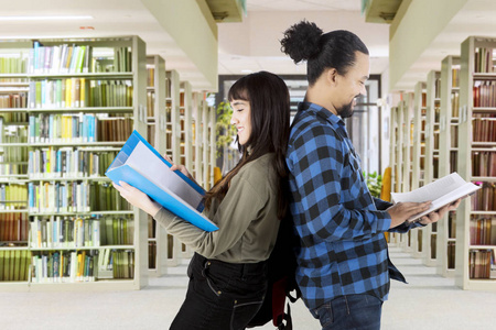 两个多种族的学生站在图书馆