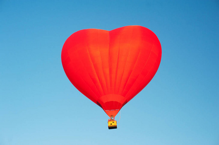 红热气球形状的一颗心在清澈的蓝天。浮空器领域的景色