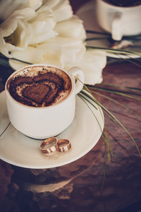 一杯咖啡结婚戒指和结婚花束郁金香