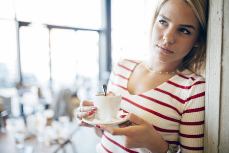 一个美丽的女人喝咖啡的肖像