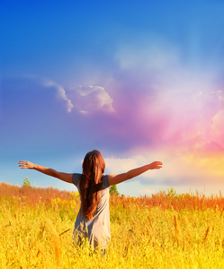 快乐的女孩在阳光明媚的草地上享受快乐照片