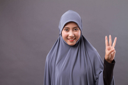 女人指着号码 3 向上，亚洲的穆斯林女人模型