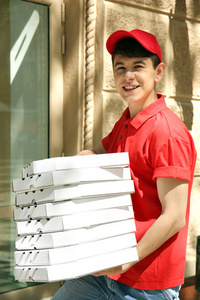 年轻男子送比萨盒附近的房子