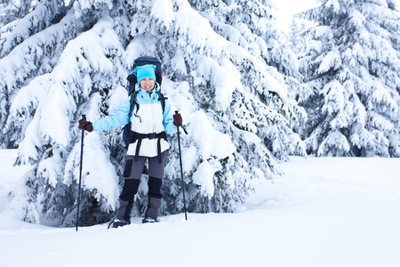 徒步旅行者在雪森林行走