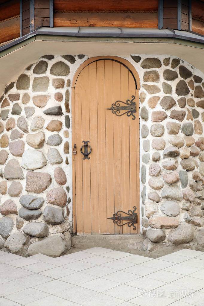 在石墙上拱形中世纪木质门