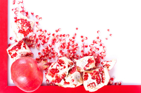 成熟的石榴果实，种子在白色背景上孤立的红框。饮食的框架。文本的自由空间
