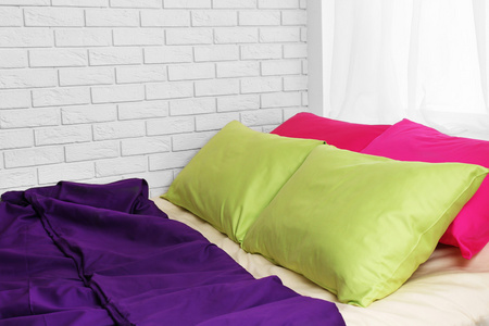 舒适的床，在卧室里的多彩枕头
