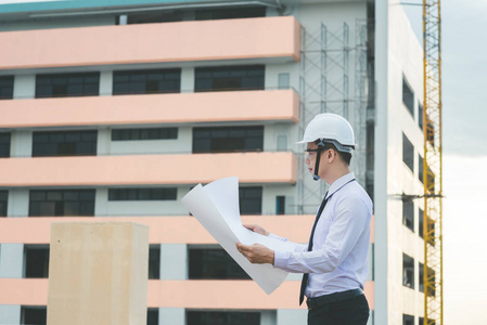 微笑年轻建筑师或工程安全帽与生成器