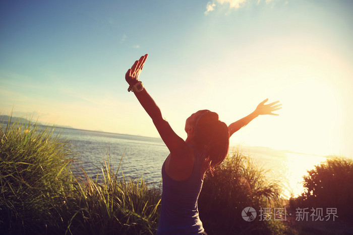 女人在日出时张开双臂