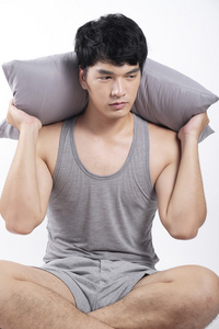 亚洲人，灰色睡衣坐，抱着枕头