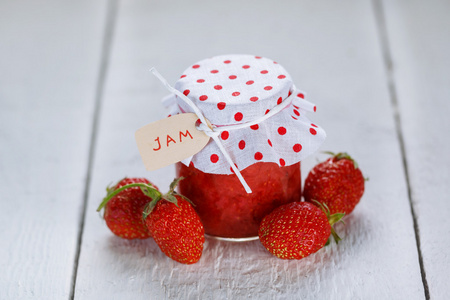 新鲜草莓自制果酱在白色背景上的罐子里。健康有机食品和素食食品