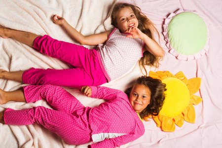 穿着粉红色睡衣的孩子玩得开心。孩子们带着笑脸