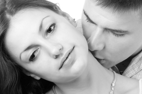 年轻夫妇接吻孤立在白色背景