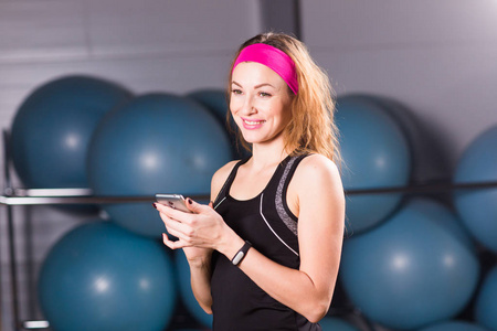 体育 健身 技术和人的概念   活动跟踪和智能手机在健身房的年轻女子