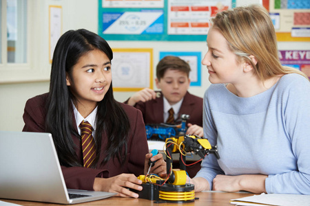 老师与学生在科学课学习机器人