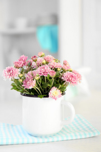 美丽的鲜花在花瓶放在桌子上，在浅色背景
