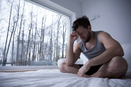人不能入睡年幼的男人受苦从痛苦向白色的背景年幼的男人受苦从痛苦向