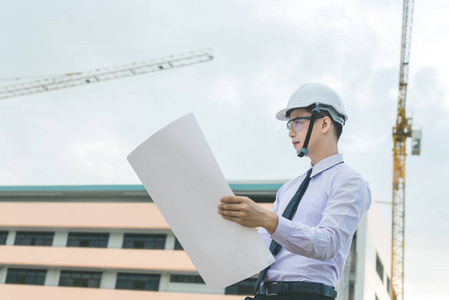 微笑年轻建筑师或工程安全帽与生成器