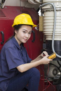 年轻的亚洲妇女工程师在实验室建立和测试机器