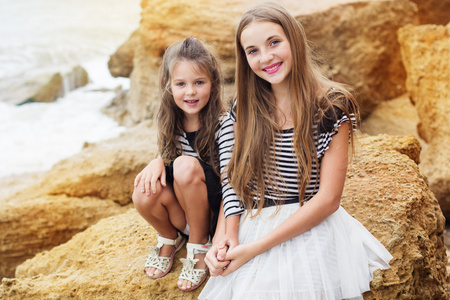 两个可爱的姐妹坐在沙滩上