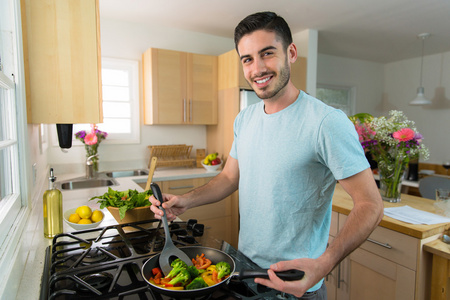 男人做饭一个英俊的男人在家做饭单独一份营养餐午餐晚餐厨师照片
