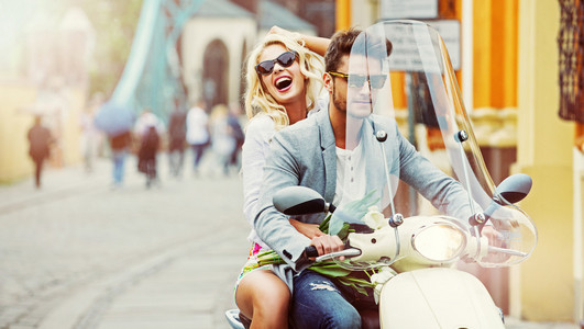 男骑头男英俊的男人骑踏板车与疯子的女孩照片