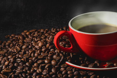热咖啡红杯和咖啡豆是背景