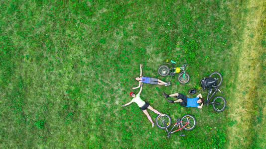 骑自行车户外鸟瞰图从上面，快乐积极的父母与孩子的家庭有乐趣和周末放松草 家庭体育和健身
